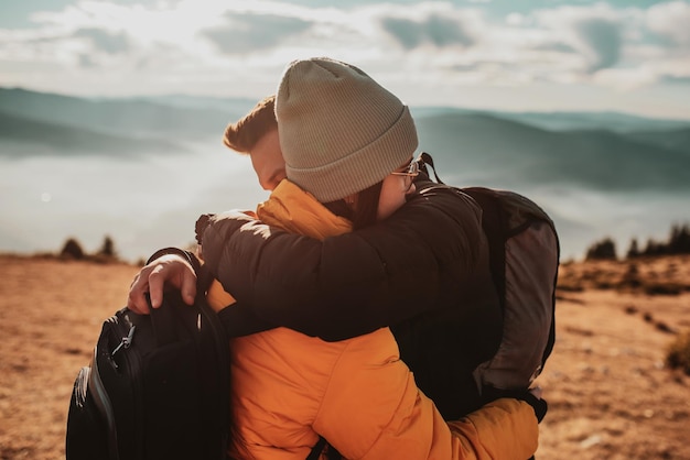 Feliz pareja hombre y mujer turista en la cima de la montaña durante una caminata en verano