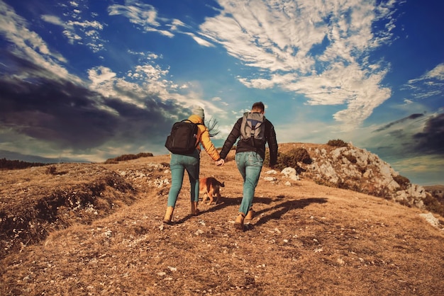 Feliz pareja hombre y mujer turista en la cima de la montaña durante una caminata en verano