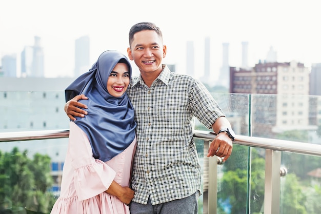 Feliz pareja indonesia en un balcón en Yakarta