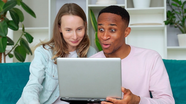 Feliz pareja interracial jugando juegos de video juntos en casa