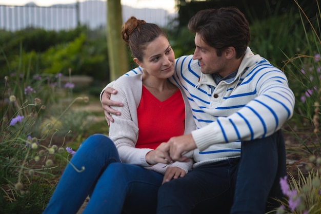 Feliz pareja joven abrazándose en el jardín