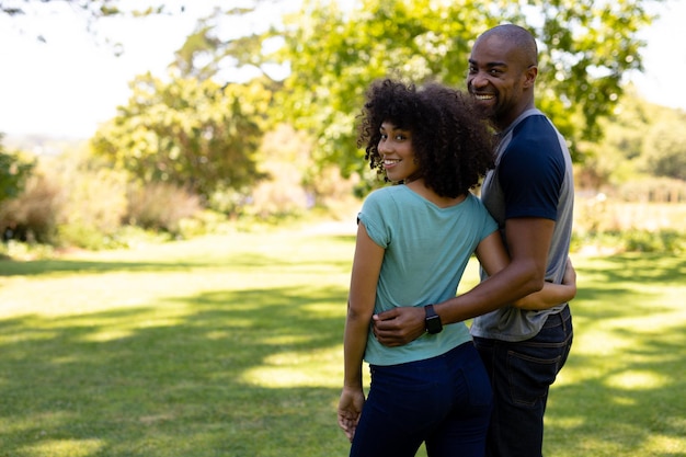 Feliz pareja joven abrazándose en el jardín