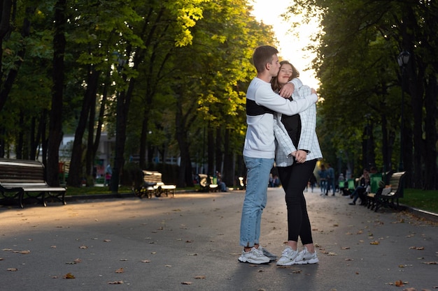 Feliz pareja joven abrazándose en el parque Retrato de tamaño completo Primera cita