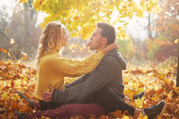 Feliz pareja joven al aire libre en un hermoso día de otoño en el bosque