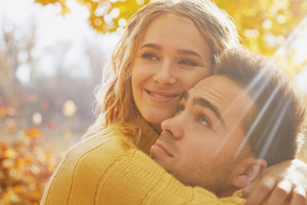 Feliz pareja joven al aire libre en un hermoso día de otoño en el bosque