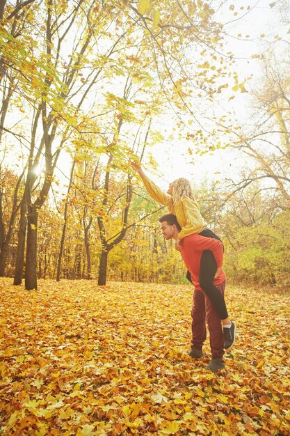 Feliz pareja joven al aire libre en un hermoso día de otoño en el bosque