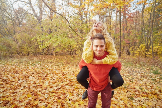 Feliz pareja joven al aire libre en un hermoso día de otoño en el bosque