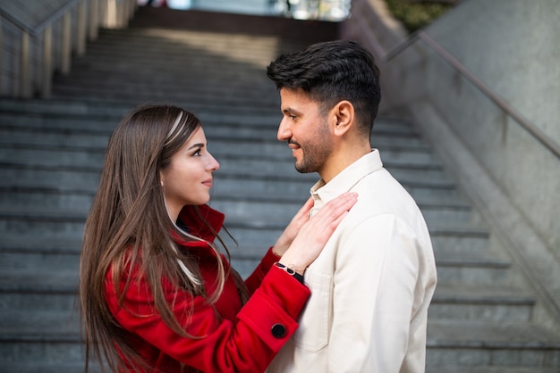 Feliz pareja joven al aire libre junto a las escaleras