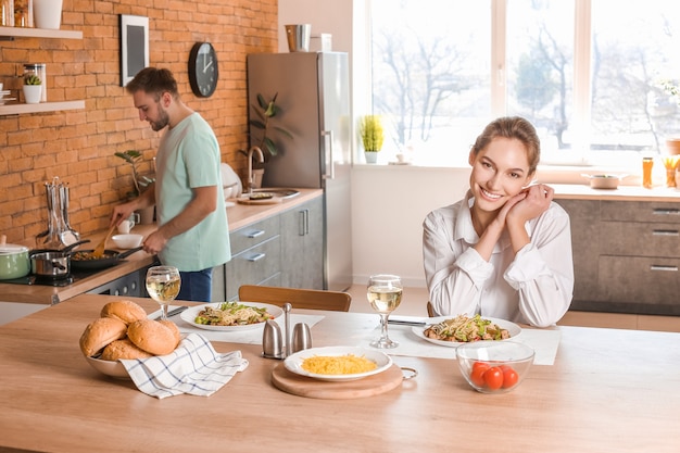 Feliz pareja joven almorzando en la cocina