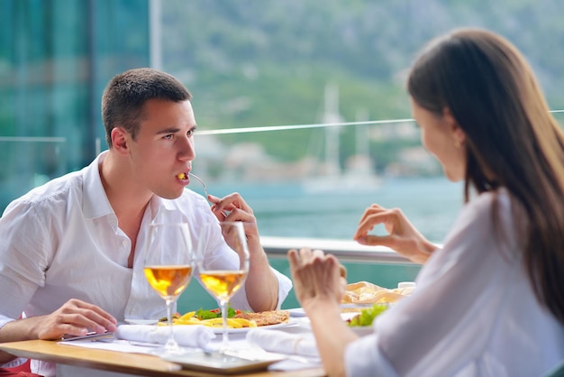 feliz pareja joven con almuerzo en un hermoso restaurante junto al mar en la playa