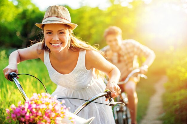 Feliz pareja joven en bicicleta por el parque