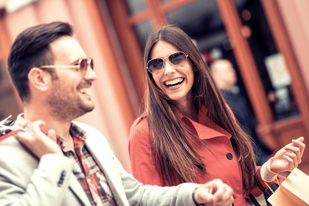 Feliz pareja joven con bolsas de compras