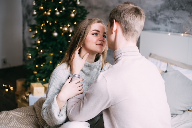 Feliz pareja joven en la cama en casa