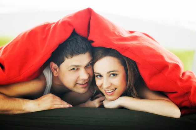 feliz pareja joven en la cama por la mañana