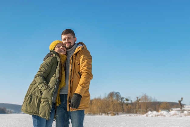 Feliz pareja joven caminando en un día soleado de invierno Gran angular de cuerpo completo