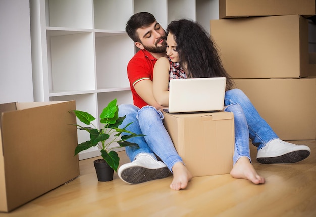 Feliz pareja joven en casa nueva desembalaje de cajas