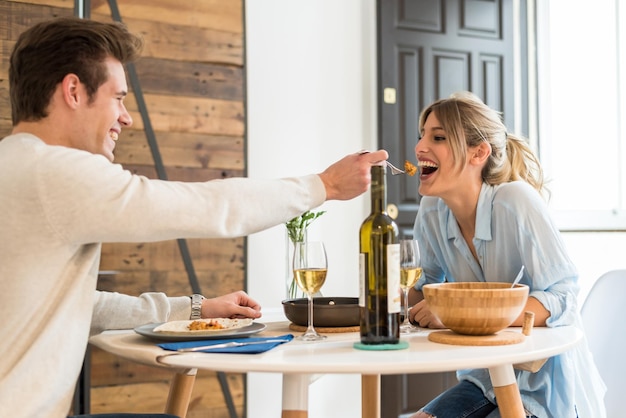 feliz pareja joven cenando en casa