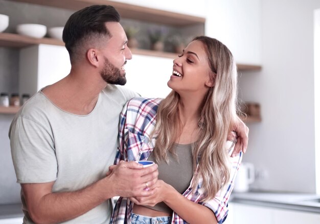 Feliz pareja joven en la cocina en buenos días