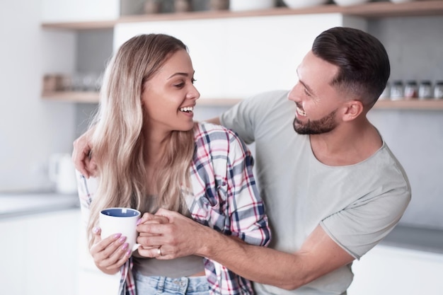 Feliz pareja joven en la cocina en buenos días