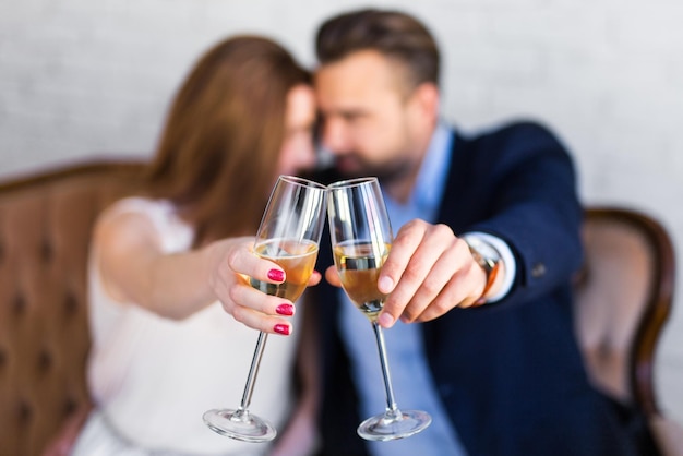 Feliz pareja joven con copas de champán sentado en el restaurante