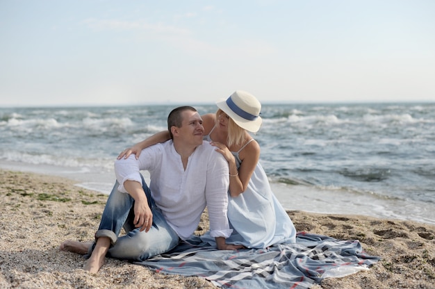 Feliz pareja joven descansa cerca del océano y besos