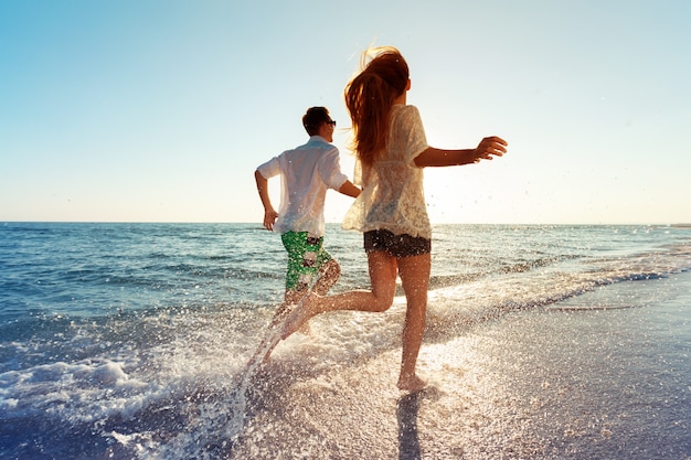 Feliz pareja joven disfrutando del mar