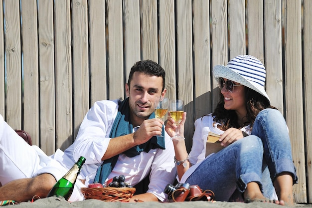 feliz pareja joven disfrutando de un picnic en la playa y pasando un buen rato en las vacaciones de verano