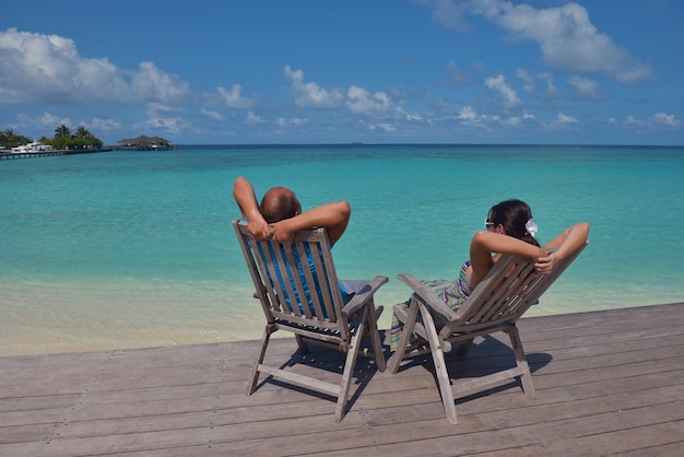 feliz pareja joven diviértase y relájese en las vacaciones de verano en el lugar de viaje de maldivas de fondo y la hermosa playa de arena blanca