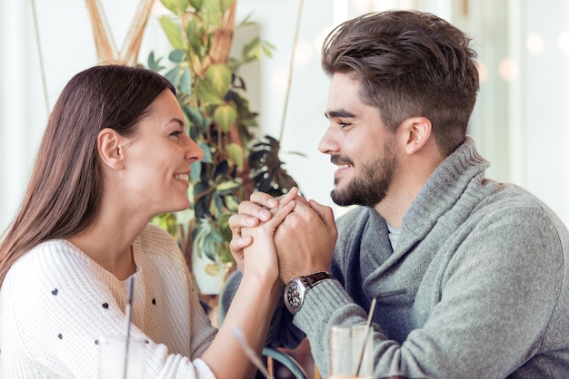 Feliz pareja joven divirtiéndose en el café