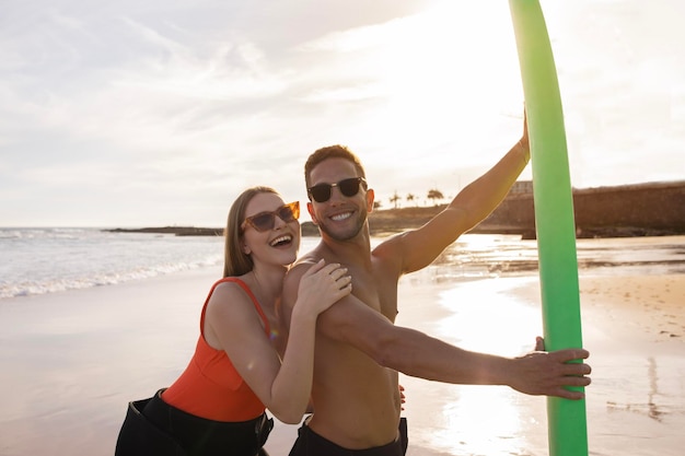 Feliz pareja joven divirtiéndose mientras navegan juntos en la playa del océano