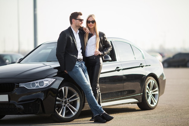 Feliz pareja joven elige y compra un auto nuevo para la familia.