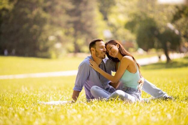 Feliz pareja joven enamorada en el campo de hierba