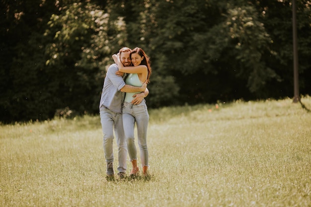 Feliz pareja joven enamorada en el campo de hierba