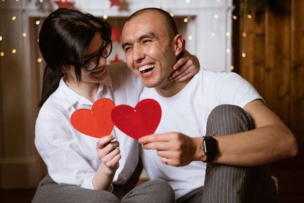 Feliz pareja joven enamorada mantenga corazón rojo en la mano enfoque suave