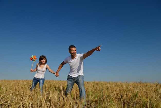 feliz pareja joven enamorada tiene romance y diversión en el campo de trigo en verano