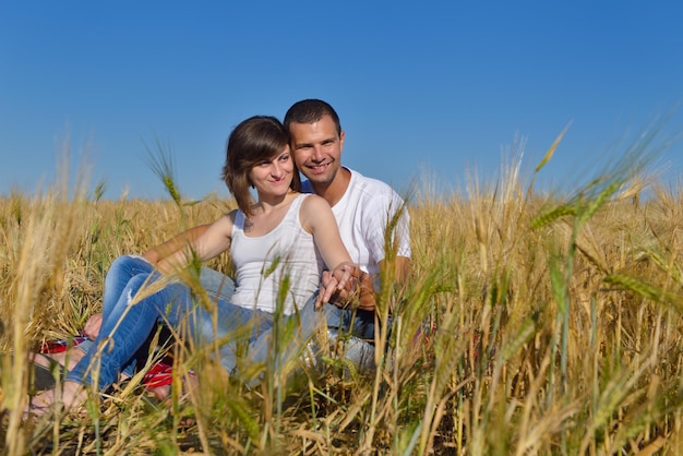 feliz pareja joven enamorada tiene romance y diversión en el campo de trigo en verano