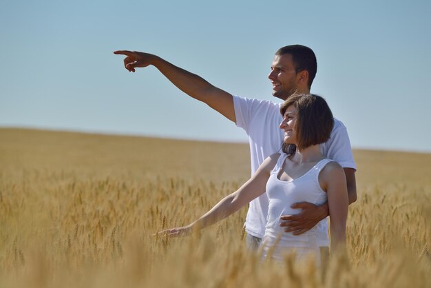 Foto feliz pareja joven enamorada tiene romance y diversión en el campo de trigo en verano