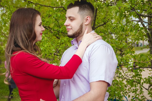 Foto feliz pareja joven esperando bebé en el parque de verano