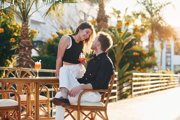 Feliz pareja joven está juntos en sus vacaciones al aire libre durante el día soleado