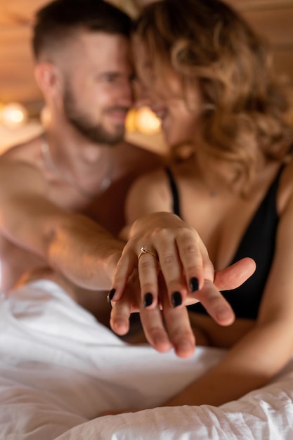 Feliz pareja joven extendiendo sus manos demuestra el concepto de anillo de compromiso de matrimonio de compromiso