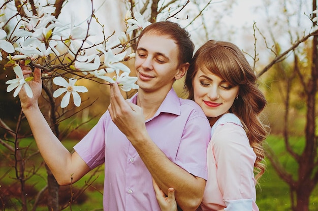 Feliz pareja joven, familia caminando en el parque de primavera. Puesta de sol. Mirada familiar. Estilo de vida. Fecha. Amor