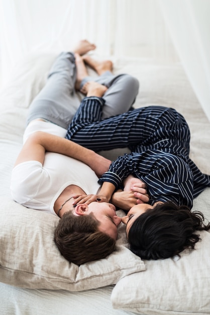 Foto feliz pareja joven feliz abrazándose en un dormitorio