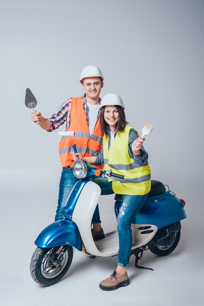 Feliz pareja joven en moto. Compras para la construcción y reparación de una nueva casa.