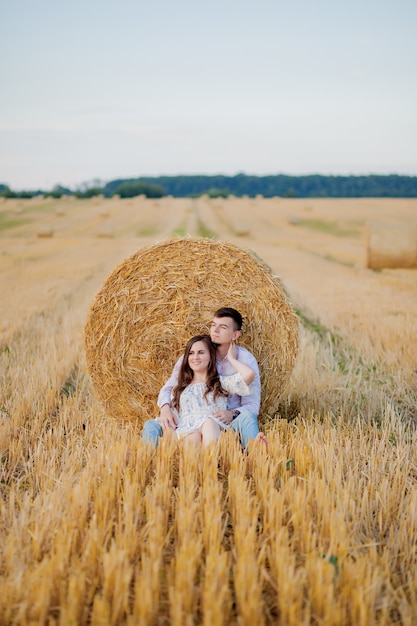 Feliz pareja joven en paja, concepto de gente romántica, hermoso paisaje, temporada de verano