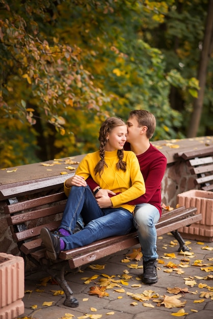 Feliz pareja joven en el parque otoño