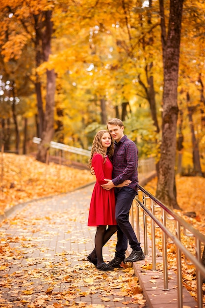 Feliz pareja joven en el parque otoño