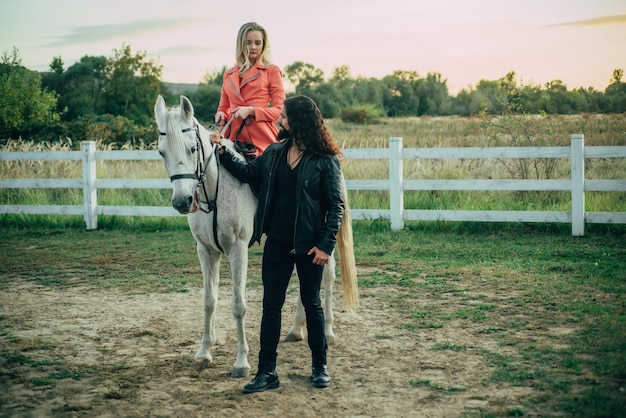 Feliz pareja joven pasar tiempo junto con sus caballos gente enamorada montando un caballo