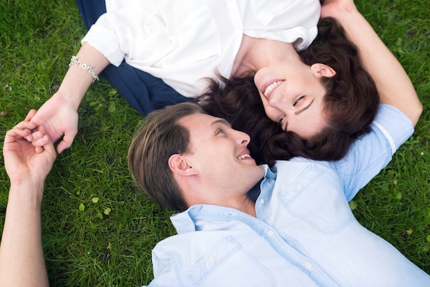 Feliz pareja joven permanecer juntos en la hierba