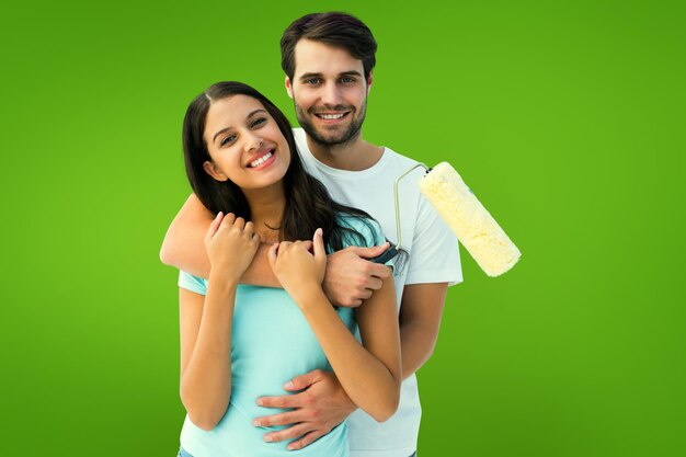 Foto feliz pareja joven pintando juntos contra viñeta verde