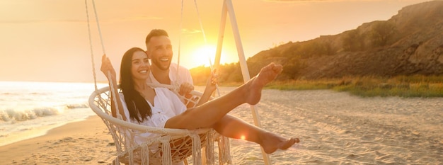 feliz, pareja joven, en, playa, en, ocaso, bandera, diseño